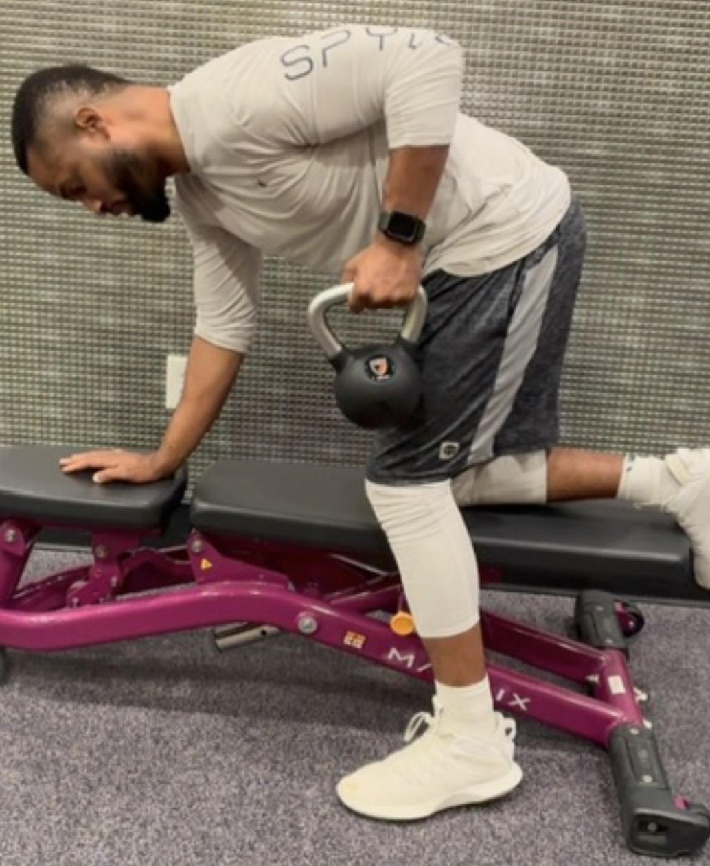 Coach Mike performing a one-arm dumbbell row